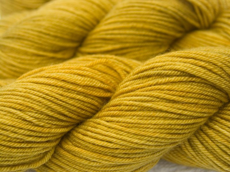 Ochre yellow Bluefaced Leicester, silk & cashmere double knit yarn. Hand-dyed by Triskelion Yarn.