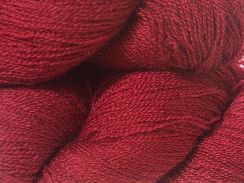 Semi-solid deep red Bluefaced Leicester laceweight yarn hand-dyed by Triskelion Yarns