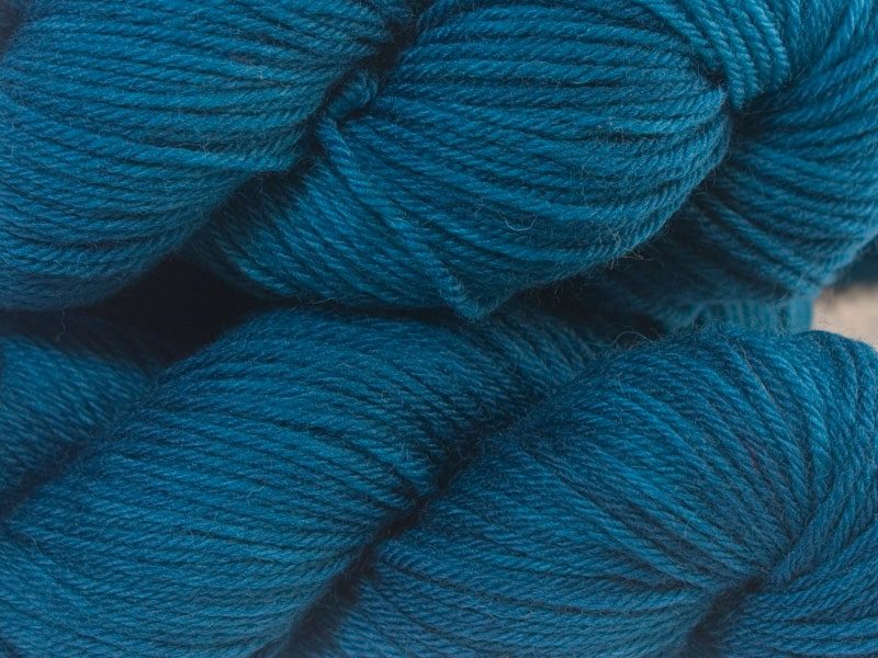 Semi-solid cerulean blue superwash British Bluefaced Leicester sportweight yarn. hand-dyed by Triskelion Yarn