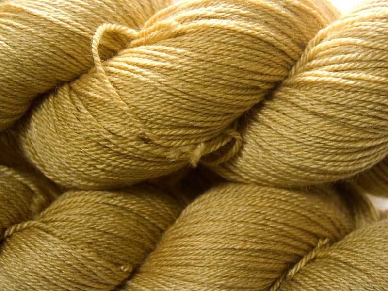 Sandy golden yellow Bluefaced Leicester, silk & cashmere 4-ply yarn. Hand-dyed by Triskelion Yarn.