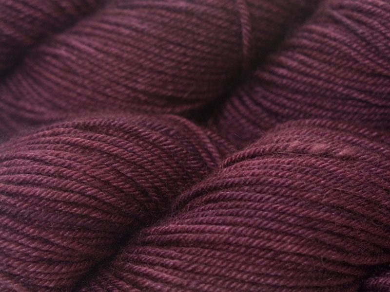 Mid-tone violet red Bluefaced Leicester, silk & cashmere double knit yarn. Hand-dyed by Triskelion Yarn.