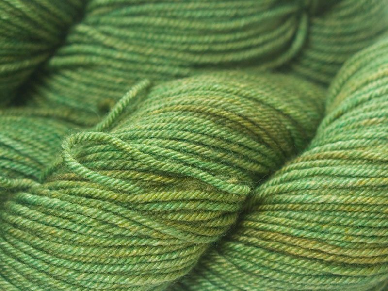 Mid-tone grassy green Bluefaced Leicester, silk & cashmere double knit yarn. Hand-dyed by Triskelion Yarn.