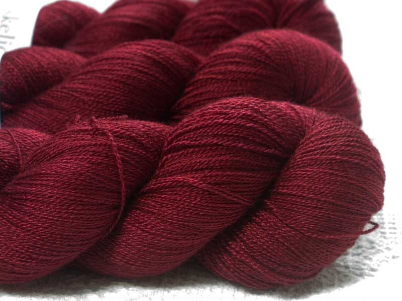 Semi-solid deep red Bluefaced Leicester laceweight yarn. Hand-dyed by Triskelion Yarn.