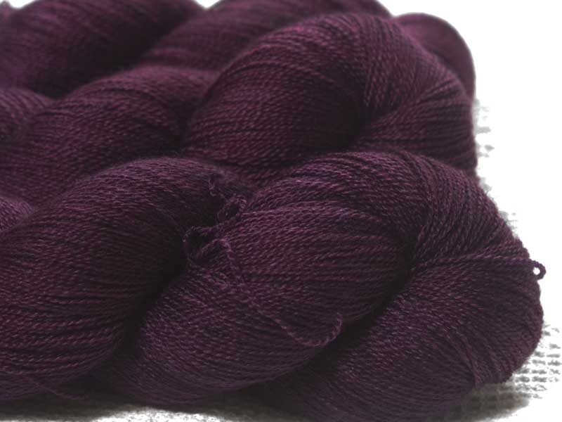 Mid-tone violet red Bluefaced Leicester laceweight yarn. Hand-dyed by Triskelion Yarn.