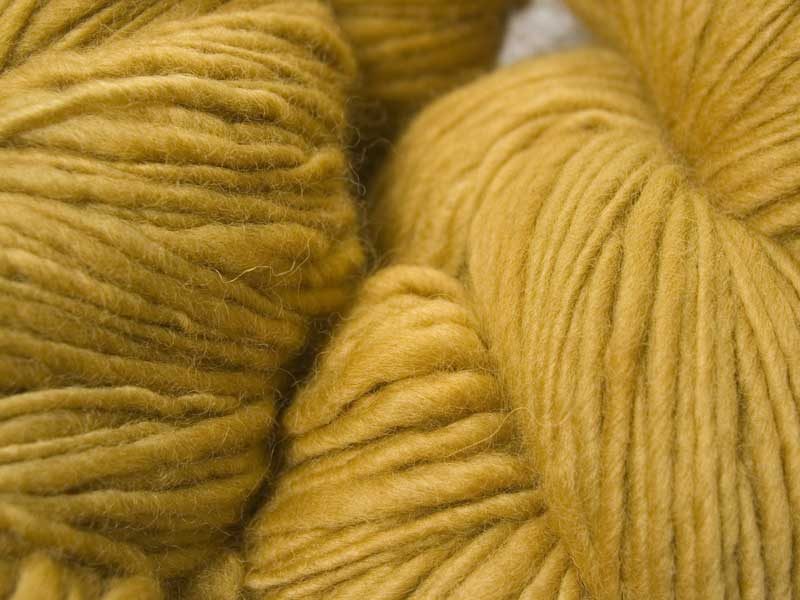 Sandy golden yellow Corriedale thick and thin slub yarn. Hand-dyed by Triskelion Yarn.