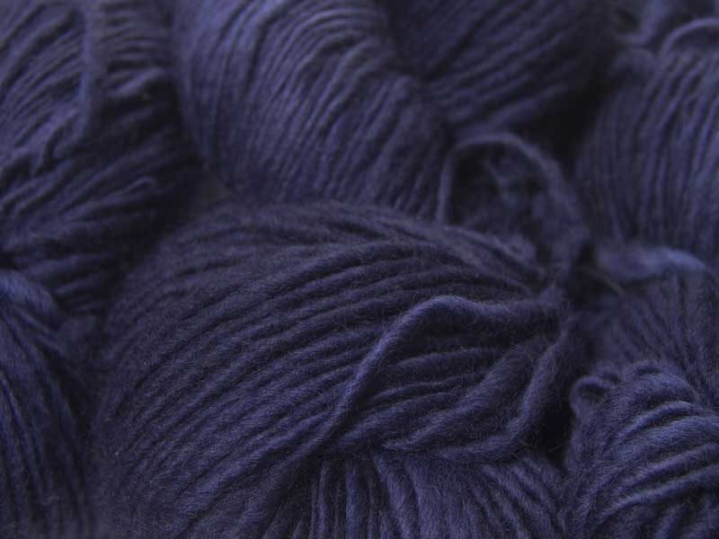 Semi-solid deep purple and blue-violet Corriedale thick and thin slub yarn. Hand-dyed by Triskelion Yarn.