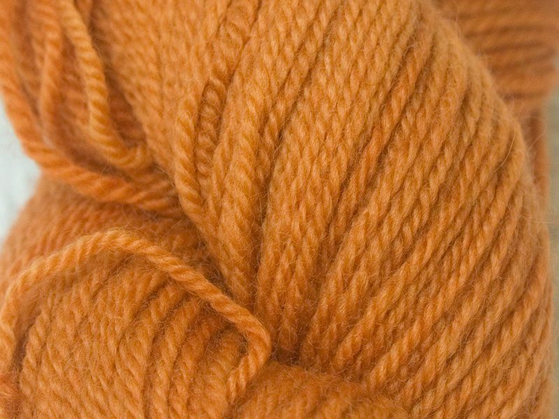 Semi-solid light orange Bluefaced Leicester (BFL) double knit yarn. Hand-dyed by Triskelion Yarn