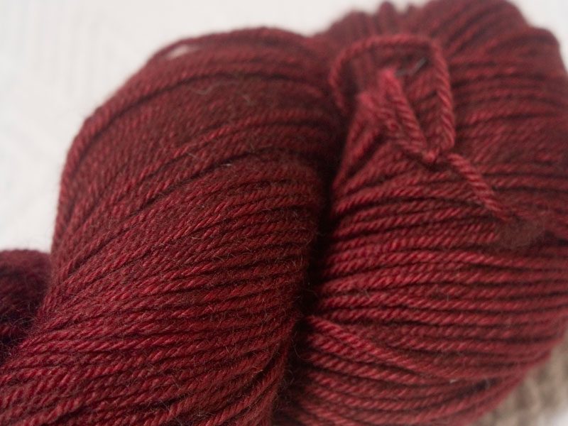Dark red superwash Bluefaced Leicester (BFL) double knit yarn. Hand-dyed by Triskelion Yarn