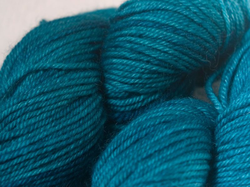 Mid-tone turquoise superwash Bluefaced Leicester (BFL) double knit yarn. Hand-dyed by Triskelion Yarn