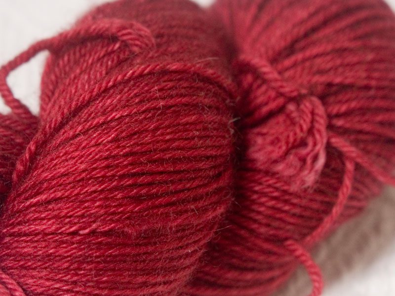 Red superwash Bluefaced Leicester (BFL) double knit yarn. Hand-dyed by Triskelion Yarn