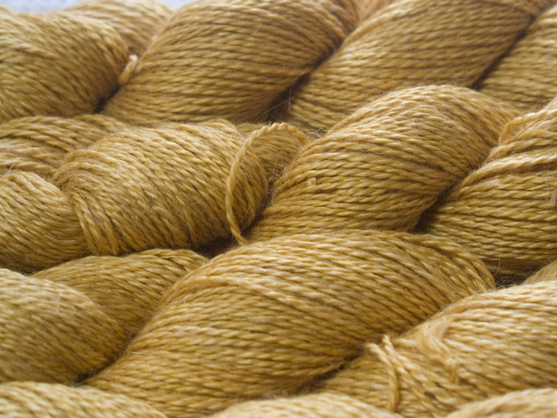 Sandy golden yellow Baby Alpaca, silk and linen sport weight yarn. Hand-dyed by Triskelion Yarn.