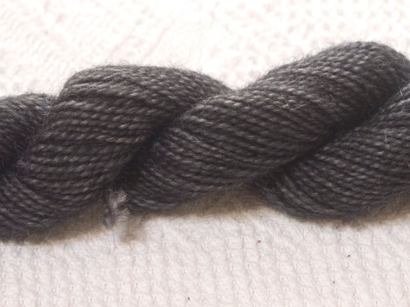 Maes Glo - Dark charcoal grey superwash Bluefaced Leicester (BFL) 4-ply/fingering/sock yarn mini skein. Hand-dyed by Triskelion Yarn