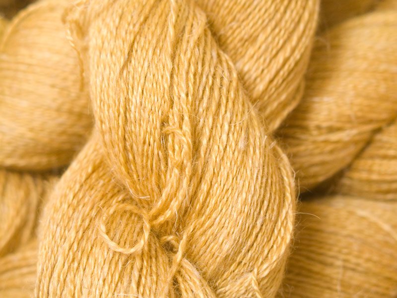 Sandy golden yellow Baby Alpaca, silk and linen heavy laceweight yarn. Hand-dyed by Triskelion Yarn.