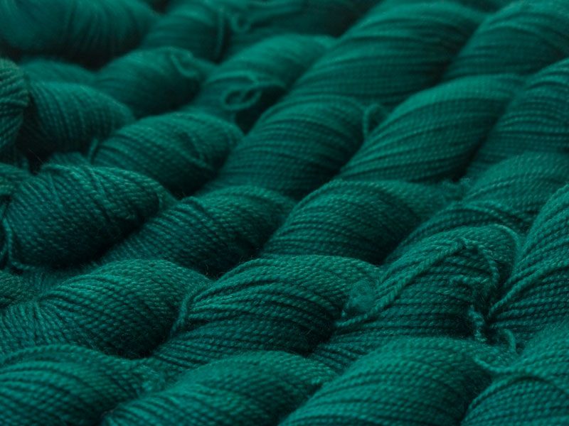 Mid to dark bluish-green superwash Bluefaced Leicester (BFL) 4-ply/fingering/sock yarn. Hand-dyed by Triskelion Yarn