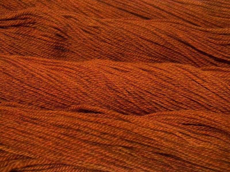 Semi-solid dark orange, with tones of copper, vermillion and russet Bluefaced Leicester (BFL) / Masham aran yarn. Hand-dyed by Triskelion Yarn