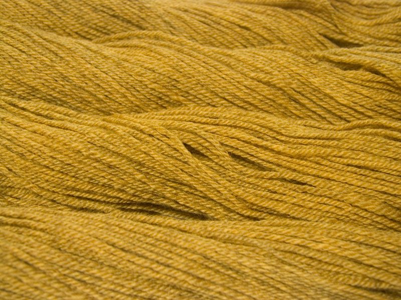 Semi-solid yellow, with tones of ochre and antique gold Bluefaced Leicester (BFL) / Masham aran yarn. Hand-dyed by Triskelion Yarn