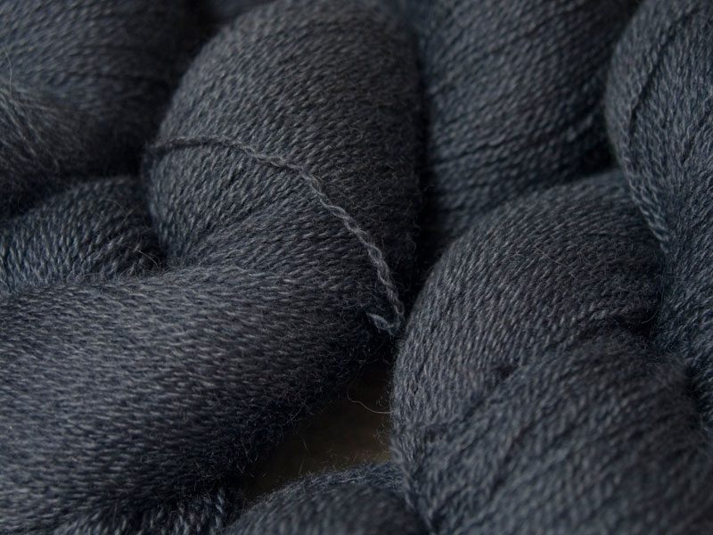 Semi-solid mid to dark grey, with tones of stormy blue and violet Bluefaced Leicester laceweight yarn hand-dyed by Triskelion Yarns