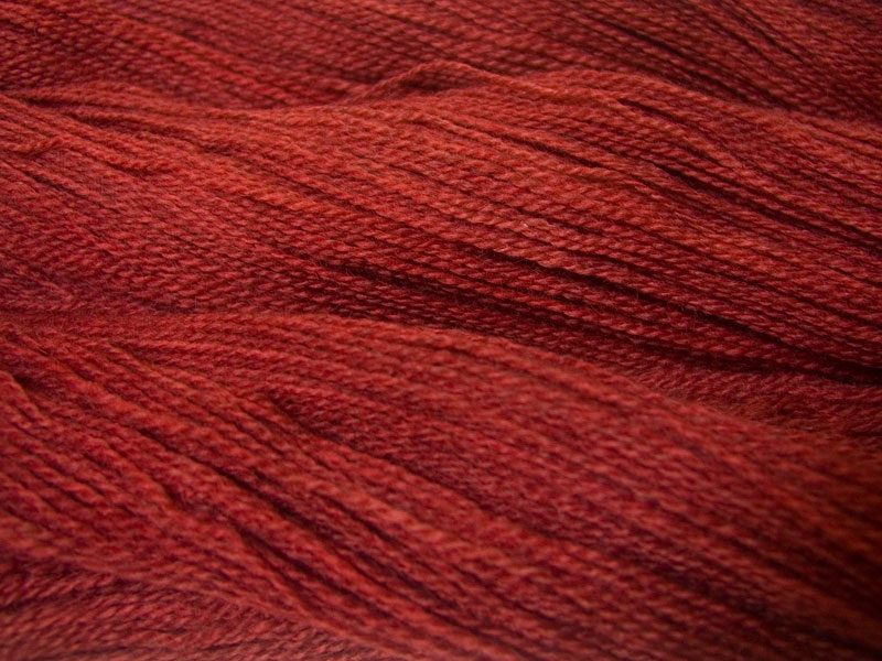Semi-solid mid red, with brick and scarlet tones Bluefaced Leicester (BFL) / Gotland 4-ply (fingering) yarn. Hand-dyed by Triskelion Yarn