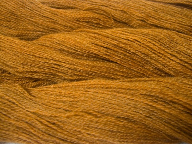 Semi-solid light orange, with tones of ochre and scarlet Bluefaced Leicester (BFL) / Gotland 4-ply (fingering) yarn. Hand-dyed by Triskelion Yarn