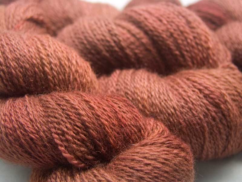 Autumnal orange-brown with red and dark brown variations Bluefaced Leicester (BFL) / Masham aran yarn. Hand-dyed by Triskelion Yarn