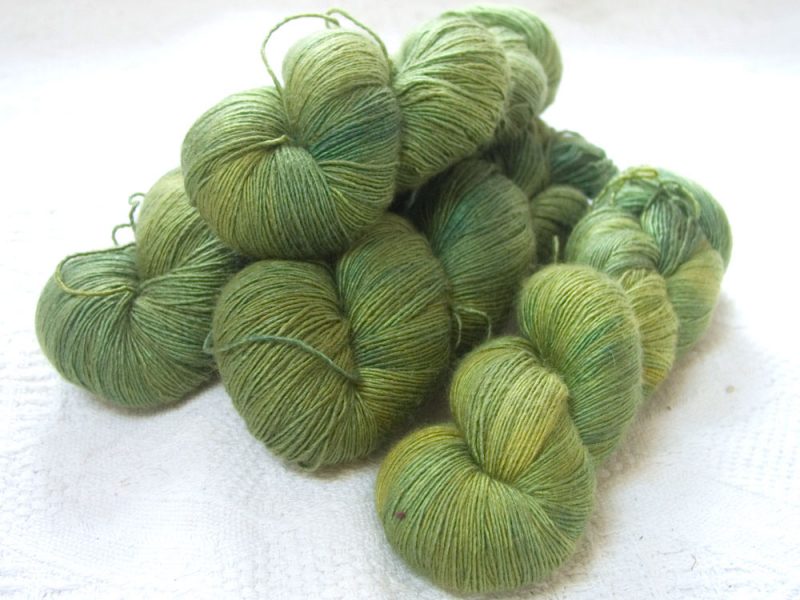 Semi-solid pasture green with yellow tonal variations Falklands Merino and silk blend yarn. Hand-dyed by Triskelion Yarn.