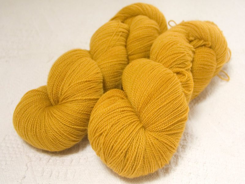 Saint Polly Garter - Semi-solid yellow, with tones of ochre and antique gold extra fine Falklands Merino 2-ply laceweight yarn hand-dyed by Triskelion Yarns