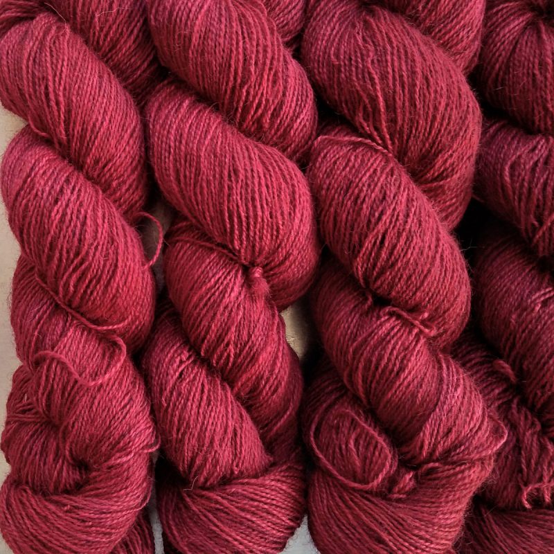 Wyrd - Deep cherry red Bluefaced Leicester (BFL) / Gotland / Wensleydale 4-ply (fingering) weight high-twist sock yarn. Hand-dyed by Triskelion Yarn